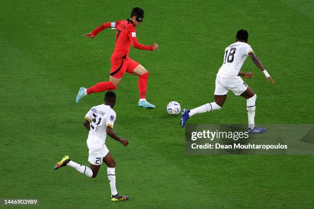 Son Heung-Min of Korea Republic battles for the ball with Daniel Amartey and Salis Abdul Samed of Ghana during the FIFA World Cup Qatar 2022 Group H...