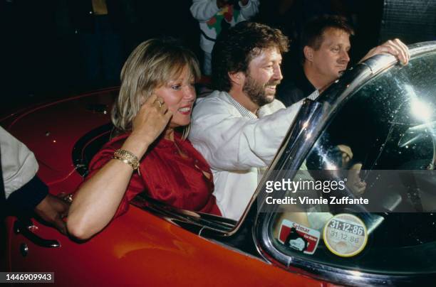 British guitarist Eric Clapton with his wife, Pattie Boyd in a car, circa 1987.