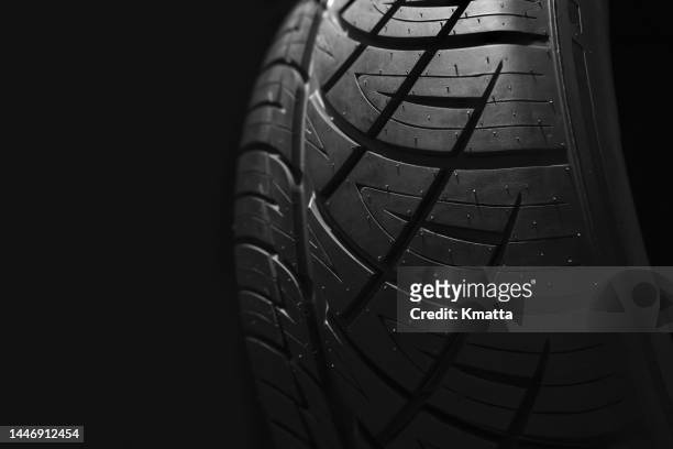 close-up of new car tire profile against black background. - neumaticos fotografías e imágenes de stock