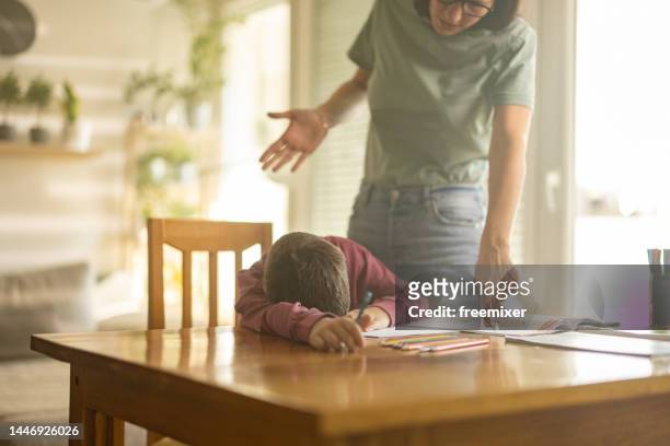 mother doing homework with son - angry boy stockfoto's en -beelden