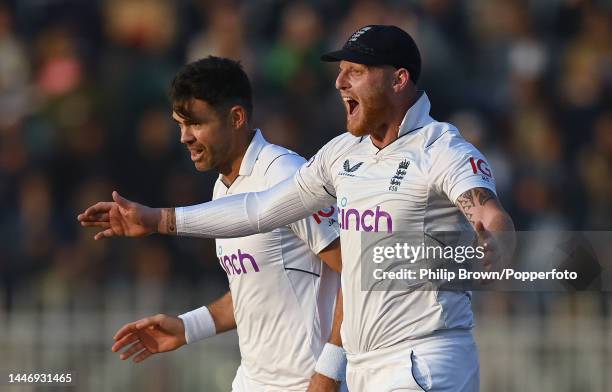 James Anderson and Ben Stokes celebrate the dismissal of Zahid Mahmood during the first Test between Pakistan and England at Rawalpindi Cricket...