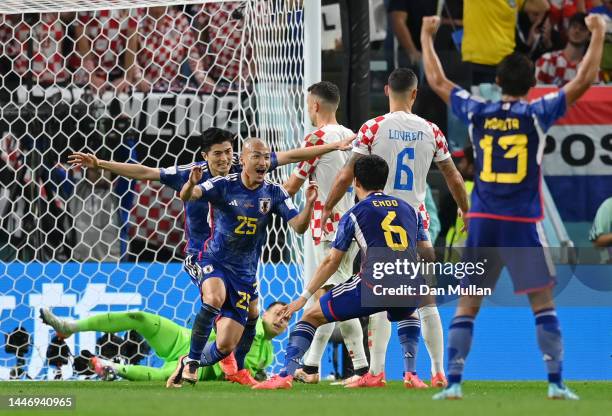 Daizen Maeda of Japan celebrates with teammates after scoring the team's first goal during the FIFA World Cup Qatar 2022 Round of 16 match between...