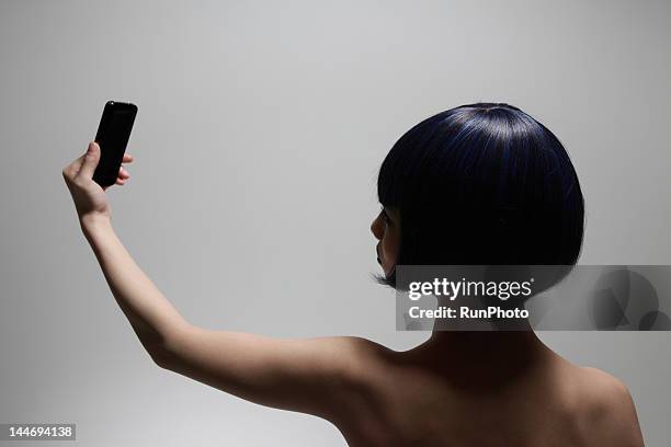 young woman looking at mobile phone - nudity foto e immagini stock