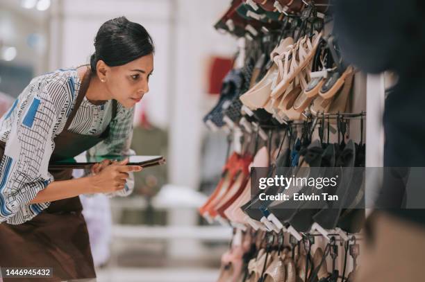 asian indian female boutique shop clothing store owner checking stock with digital tablet - shoe shop assistant stock pictures, royalty-free photos & images