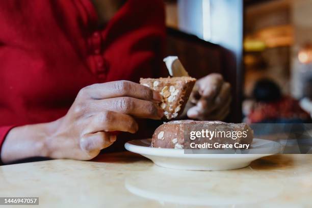 woman butters her bread at restaurant - eating brown bread stock pictures, royalty-free photos & images