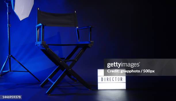 director chair with cinema lightbox sign director text on it and clapperboard megaphone,bangkok,thailand - directors chair stockfoto's en -beelden