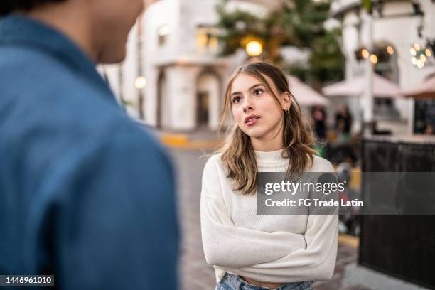 pareja joven teniendo una discusión al aire libre - angry women fotografías e imágenes de stock