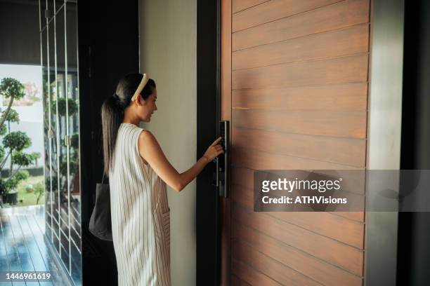 woman pressing down on electronic access control to unlock a door house - security code 個照片及圖片檔