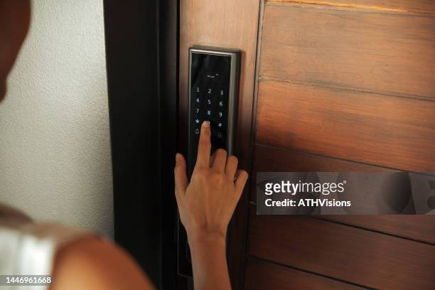 close-up woman hand pressing down on electronic access control at door house - lock stockfoto's en -beelden
