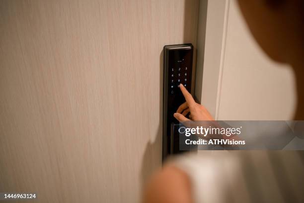 woman pressing down a password on electronic access control to unlock a door room at home - fechadura imagens e fotografias de stock