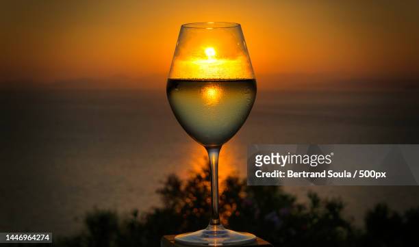 clink glass with the setting sun,france - empty wine glass stockfoto's en -beelden
