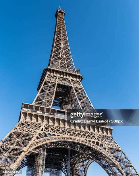 low angle view of eiffel tower against clear blue sky,champ de mars,france - eiffel tower paris stock pictures, royalty-free photos & images