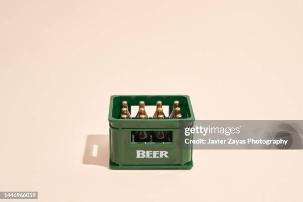 green plastic crate with beer bottles - tappo birra foto e immagini stock