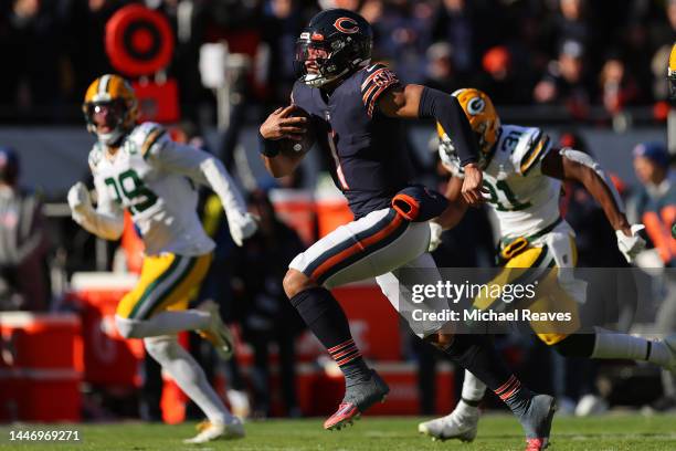 Justin Fields of the Chicago Bears runs for a touchdown against the Green Bay Packers during the first quarter at Soldier Field on December 04, 2022...