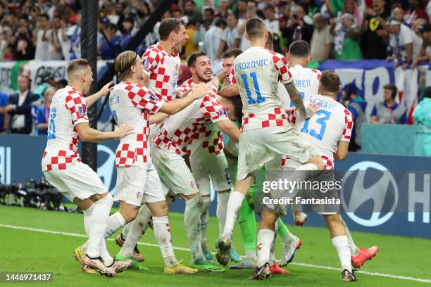 Dominik Livakovic of Croatia is mobbed by team mates after saving three penalties during the shoot out to sela the team's win and passage to the next...