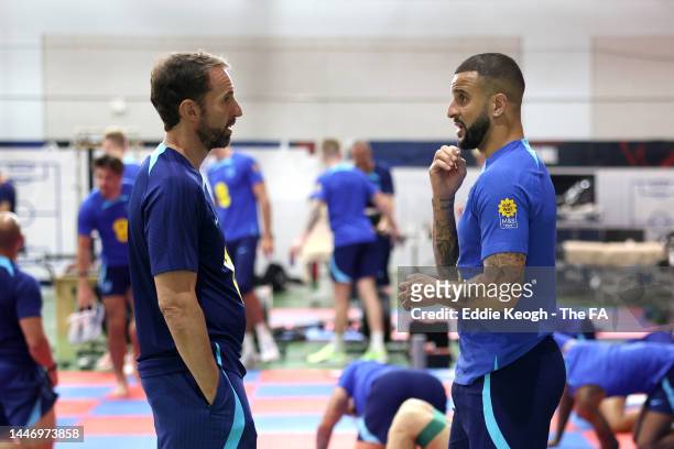 Gareth Southgate, Head Coach of England, talks to Kyle Walker of England during a training session on the day after the Round of 16 match against...