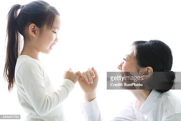 mother and daughter pinky swearing - man and woman holding hands profile stock-fotos und bilder