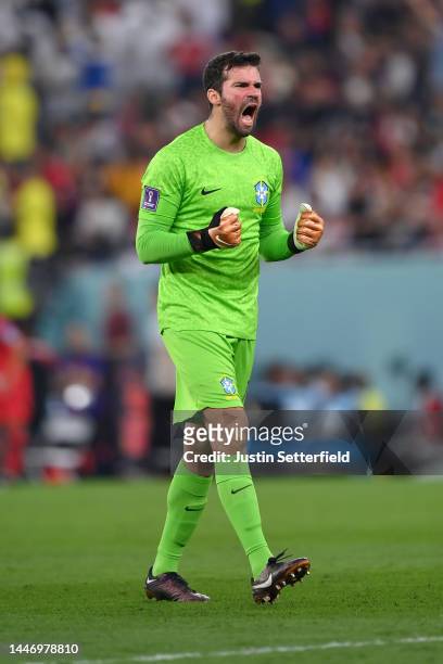Alisson Becker celebrates after Richarlison of Brazil scored their sides third goal during the FIFA World Cup Qatar 2022 Round of 16 match between...