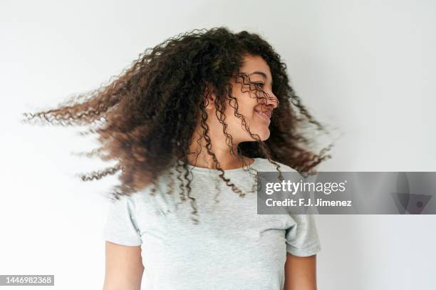 portrait of woman tossing her curly hair - shaking hair stock pictures, royalty-free photos & images