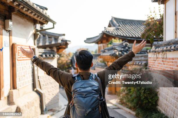 a cheerful man traveling at bukchon hanok village in seoul - kor stock pictures, royalty-free photos & images