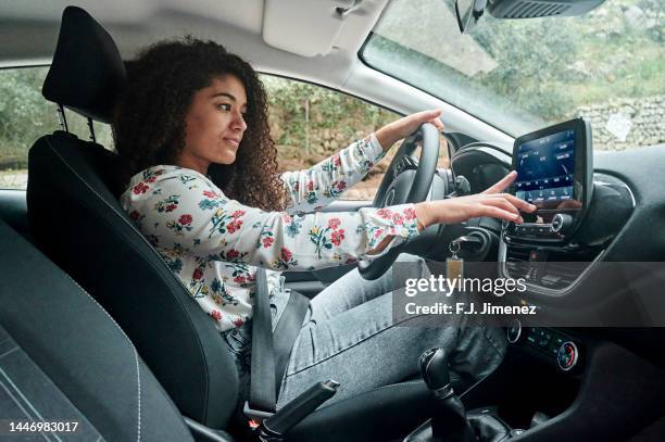 woman using digital radio in car - car dashboard foto e immagini stock