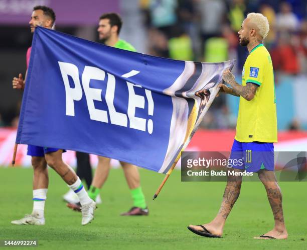 Neymar of Brazil holds a banner showing support for former Brazil player Pele after the FIFA World Cup Qatar 2022 Round of 16 match between Brazil...