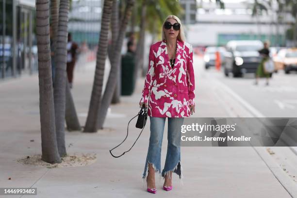 Corina Mihaila Larpin seen wearing a Schiaparelli pink and white patterned blazer, a golden necklace and belt by Schiaparelli, Amina Muaddi pink...