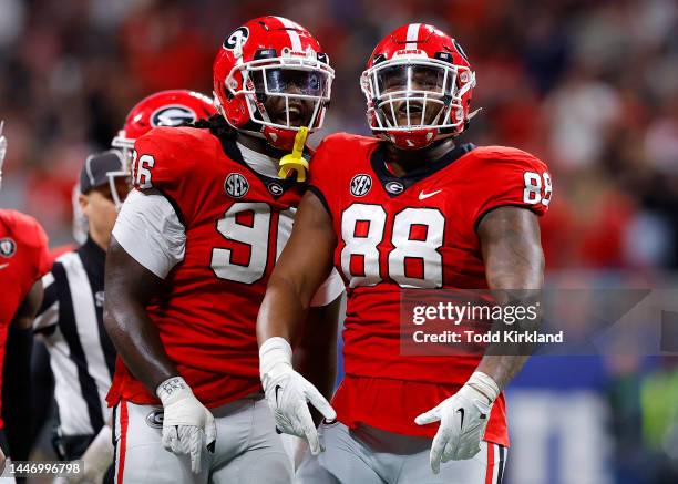 Zion Logue and Jalen Carter of the Georgia Bulldogs reacts after a stop against the LSU Tigers during the first half of the SEC Championship game at...