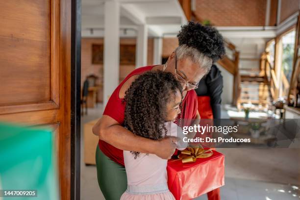 grandmother and granddaughter hugging at christmas at home - natal brazil stock pictures, royalty-free photos & images