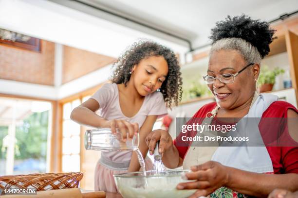 grand-mère et petites-filles faisant des biscuits de noël - faire cuire au four photos et images de collection
