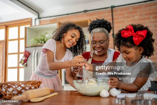 nonna e nipoti che fanno i biscotti di natale - cuocere al forno foto e immagini stock