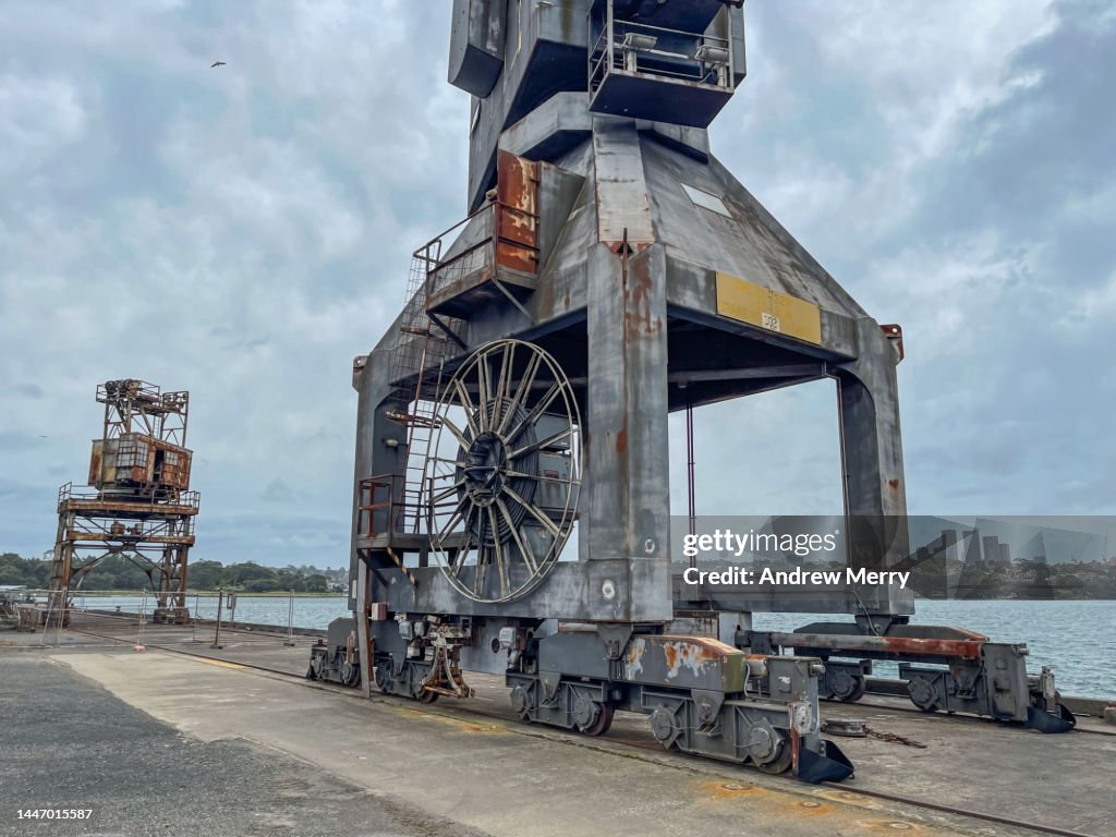 Old shipping crane on pier overcast sky