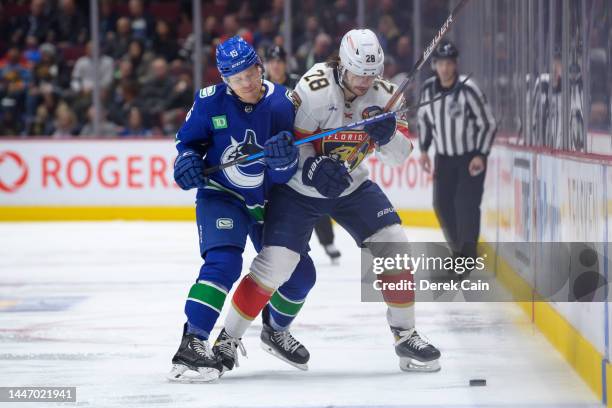 Sheldon Dries of the Vancouver Canucks and Josh Mahura of the Florida Panthers battle for the puck during the second period of their NHL game at...