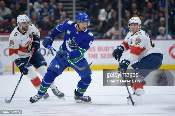 Aaron Ekblad and Gustav Forsling of the Florida Panthers defend against Dakota Joshua of the Vancouver Canucks during the first period of their NHL...