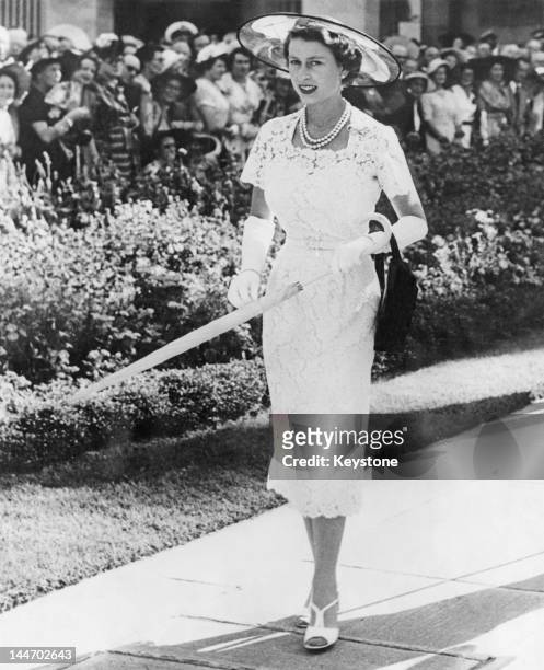 Queen Elizabeth II wears a slim-fitting white lace dress to a garden party in Sydney, Australia, before leaving for Tasmania on the liner 'SS...