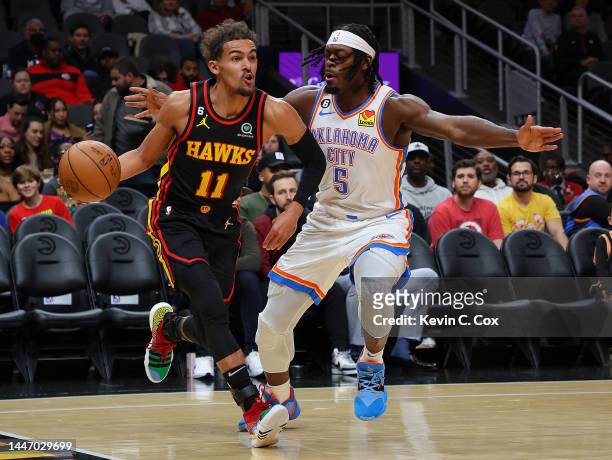 Trae Young of the Atlanta Hawks drives against Luguentz Dort of the Oklahoma City Thunder during the first half at State Farm Arena on December 05,...