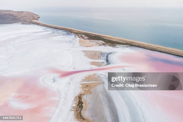 drone aerial view of salt lake flats near sea. abstract textures in natural pink color of minerals - salt flats stock-fotos und bilder