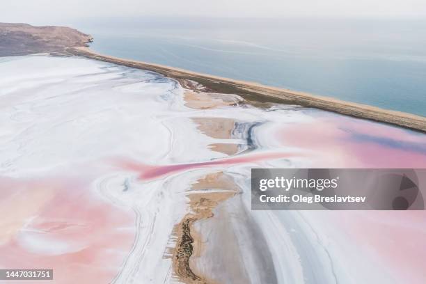 drone aerial view of salt lake flats near sea. abstract textures in natural pink color of minerals - 生理食塩水 ストックフォトと画像