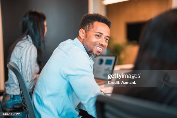 attentive multiracial man smiling at colleague during work - male back bildbanksfoton och bilder