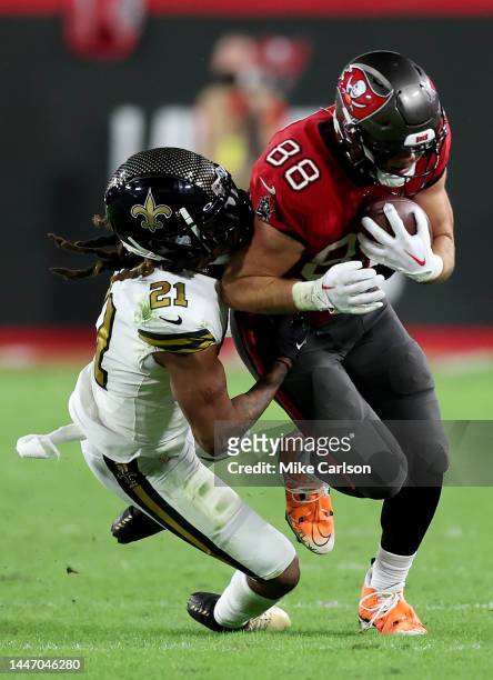 Cade Otton of the Tampa Bay Buccaneers gets tackled by Bradley Roby of the New Orleans Saints during the third quarter in the game at Raymond James...