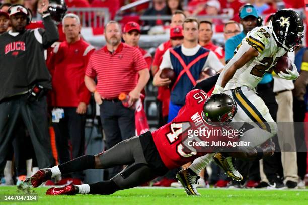 Mark Ingram II of the New Orleans Saints runs the ball against Devin White of the Tampa Bay Buccaneers during the fourth quarter in the game at...