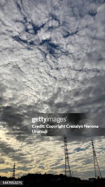 non urban scene with steel towers and beautiful clouds - tetto stock-fotos und bilder