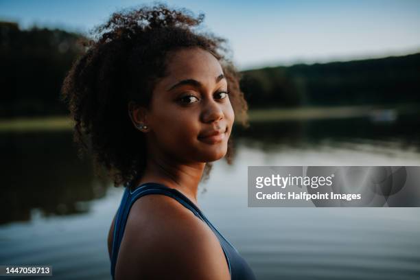 portrait of young multiracial girl at lake. - black girl swimsuit stock pictures, royalty-free photos & images