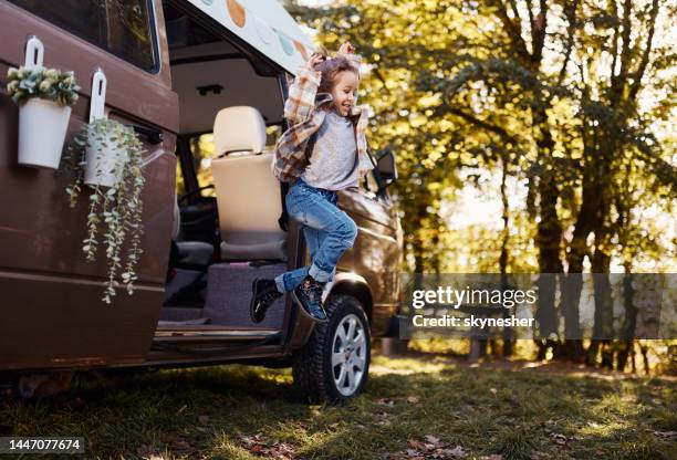 fröhliches mädchen springt aus wohnmobil in der natur. - caravan stock-fotos und bilder