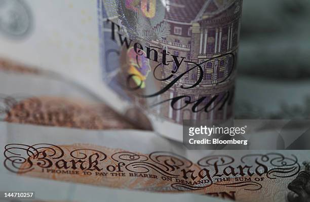 Twenty pound note sits with a set of ten pound notes in this arranged photograph in London, U.K., on Thursday, May 17, 2012. U.K. Prime Minister...
