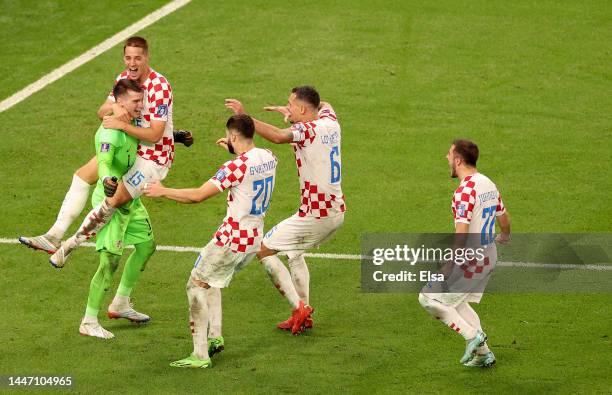 Dominik Livaković of Croatia is congratulated by teammates Mario Pašalić,Joško Gvardiol,Dejan Lovren and Josip Juranović after Croatia defeated Japan...