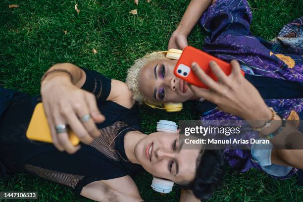 friends lying down in the park taking a selfie - change mindset stock pictures, royalty-free photos & images