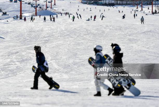 People carry skiing boards at the Silk Road International Ski Resort on December 5, 2022 in Urumqi, Xinjiang Uygur Autonomous Region of China. Ski...