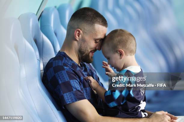 Mateo Kovacic of Croatia holds his son son Ivan Kovacic on the team bench following the FIFA World Cup Qatar 2022 Round of 16 match between Japan and...