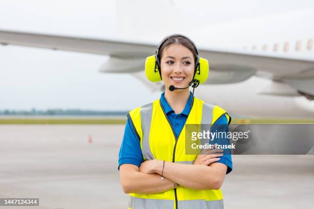 airport ground service, woman in front of airplane - woman airplane headphones bildbanksfoton och bilder
